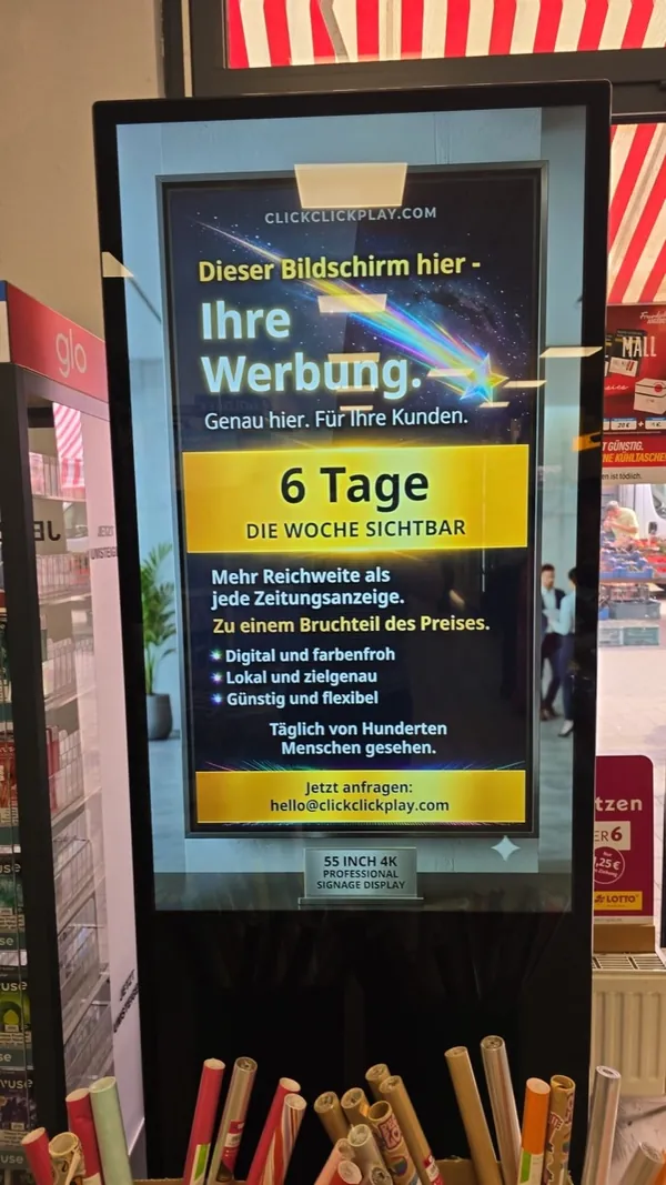 A floor-standing screen inside a post and parcel shop, inviting local businesses to advertise on it